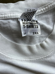 Close-up of a white t-shirt neck label reading 'FAMOUS HEAVYWEIGHT T-SHIRTS' and '2XL'.
