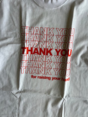 A close-up of a white t-shirt featuring a red graphic print that reads 'THANK YOU for raising your hand' in a layered, repeating style.