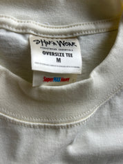 Close-up of a cream-colored oversized t-shirt showing the inner neck label which reads 'Hafa Wear Streetwear Essentials Oversize Tee M' and a 'SuperMAX Heavy' tag.
