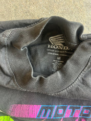 Close-up of a dark gray Honda crewneck t-shirt showing the inner neck label and part of a colorful graphic print at the bottom