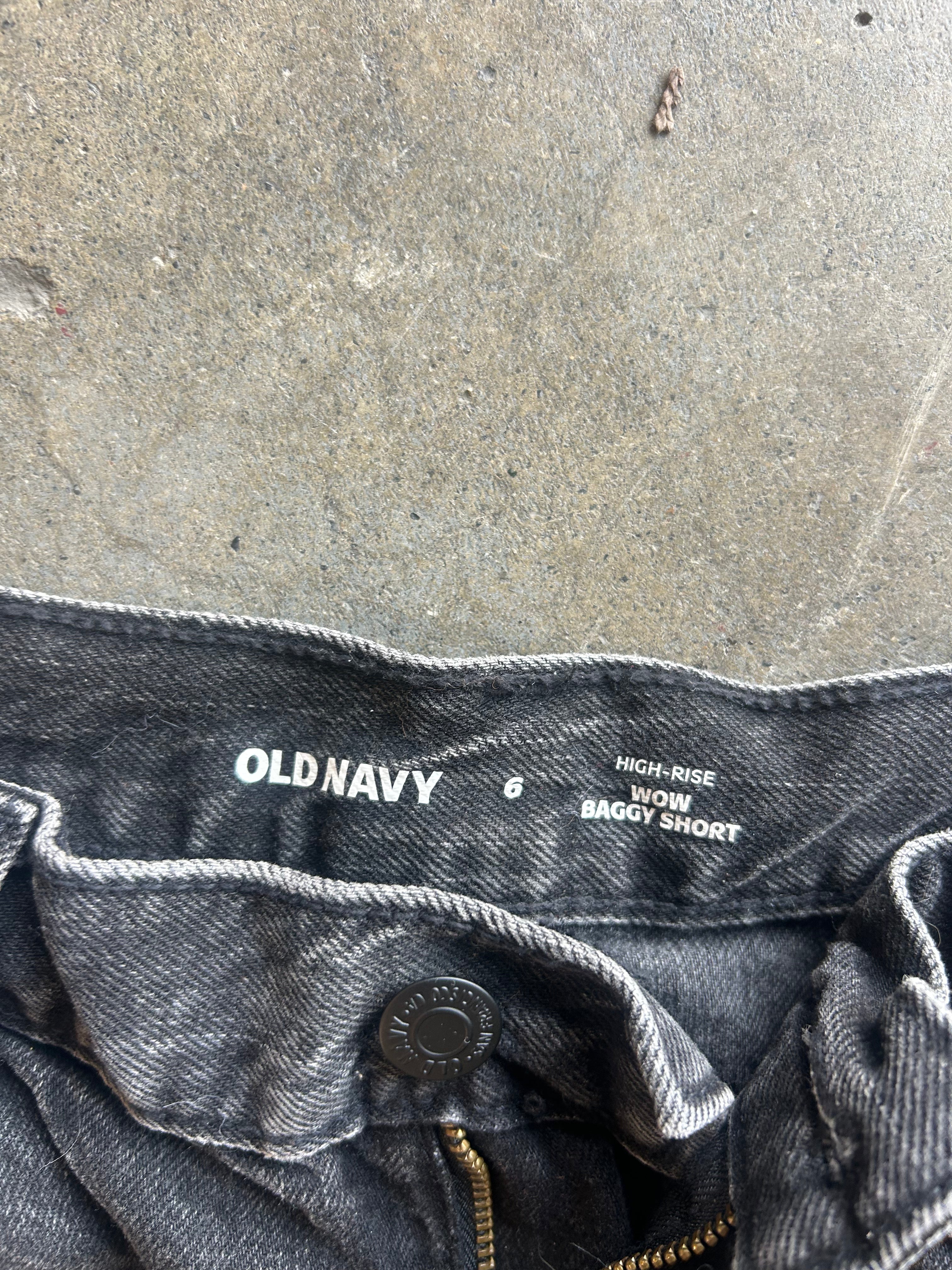 Close-up of the waistband of Old Navy high-rise baggy short jeans in a washed black denim, showing the brand name and size details on the inner label
