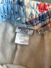Close-up of the waistband and interior labels of patterned shorts. The fabric shows a blue, red, and white plaid pattern, with a white fleece lining and a visible 'MIGHTY FINE' brand tag