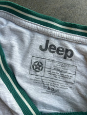 Close-up of the inside neck label of a white and green Jeep t-shirt, showing the brand name 'Jeep' and care instructions