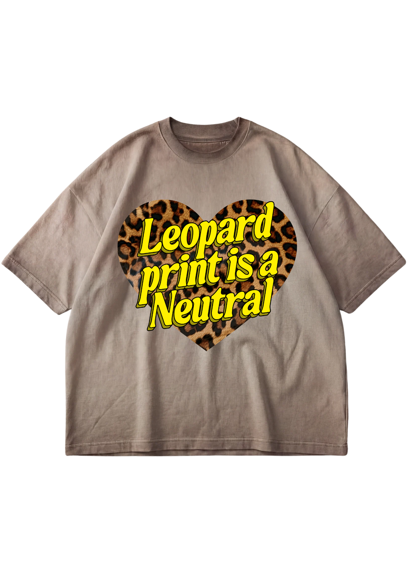 A taupe-brown short-sleeve t-shirt with a graphic on the chest featuring a leopard print heart and the text 'Leopard print is a Neutral' in yellow with a black outline, displayed on a solid white background