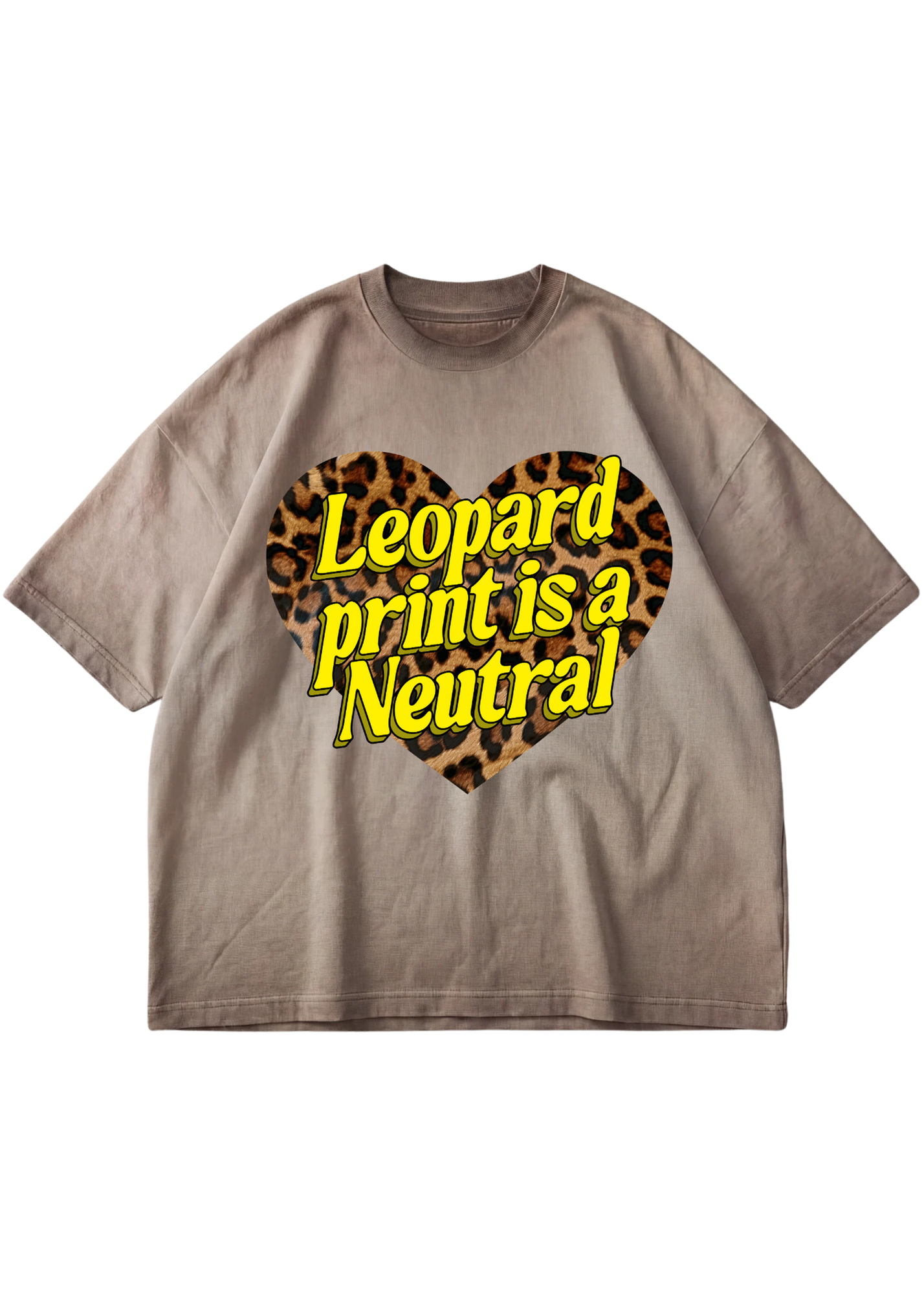 A taupe-brown short-sleeve t-shirt with a graphic on the chest featuring a leopard print heart and the text 'Leopard print is a Neutral' in yellow with a black outline, displayed on a solid white background