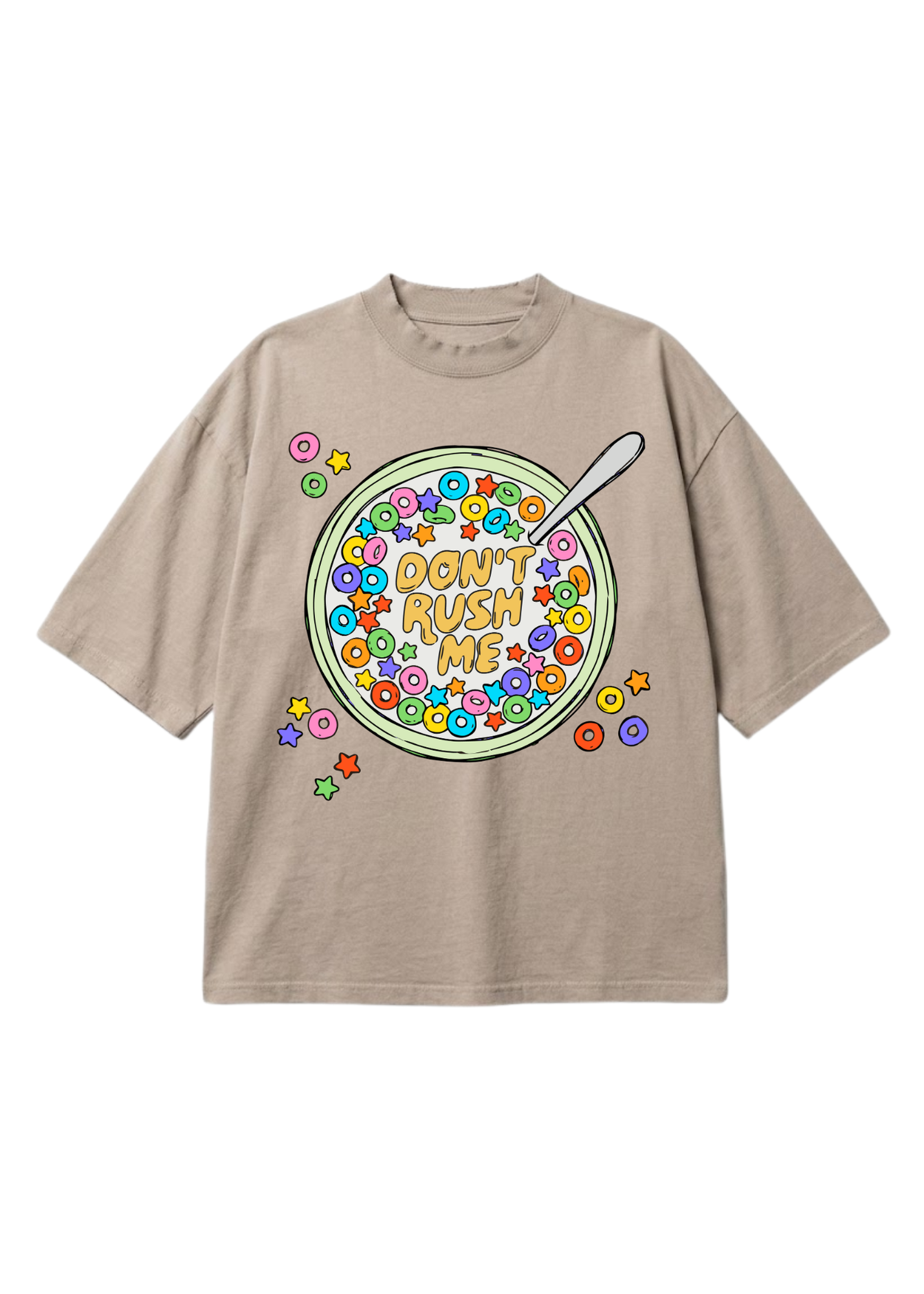 A beige short-sleeve t-shirt with a colorful graphic of a bowl of cereal on the front, featuring the text 'DON'T RUSH ME' and a spoon, set against a plain white background