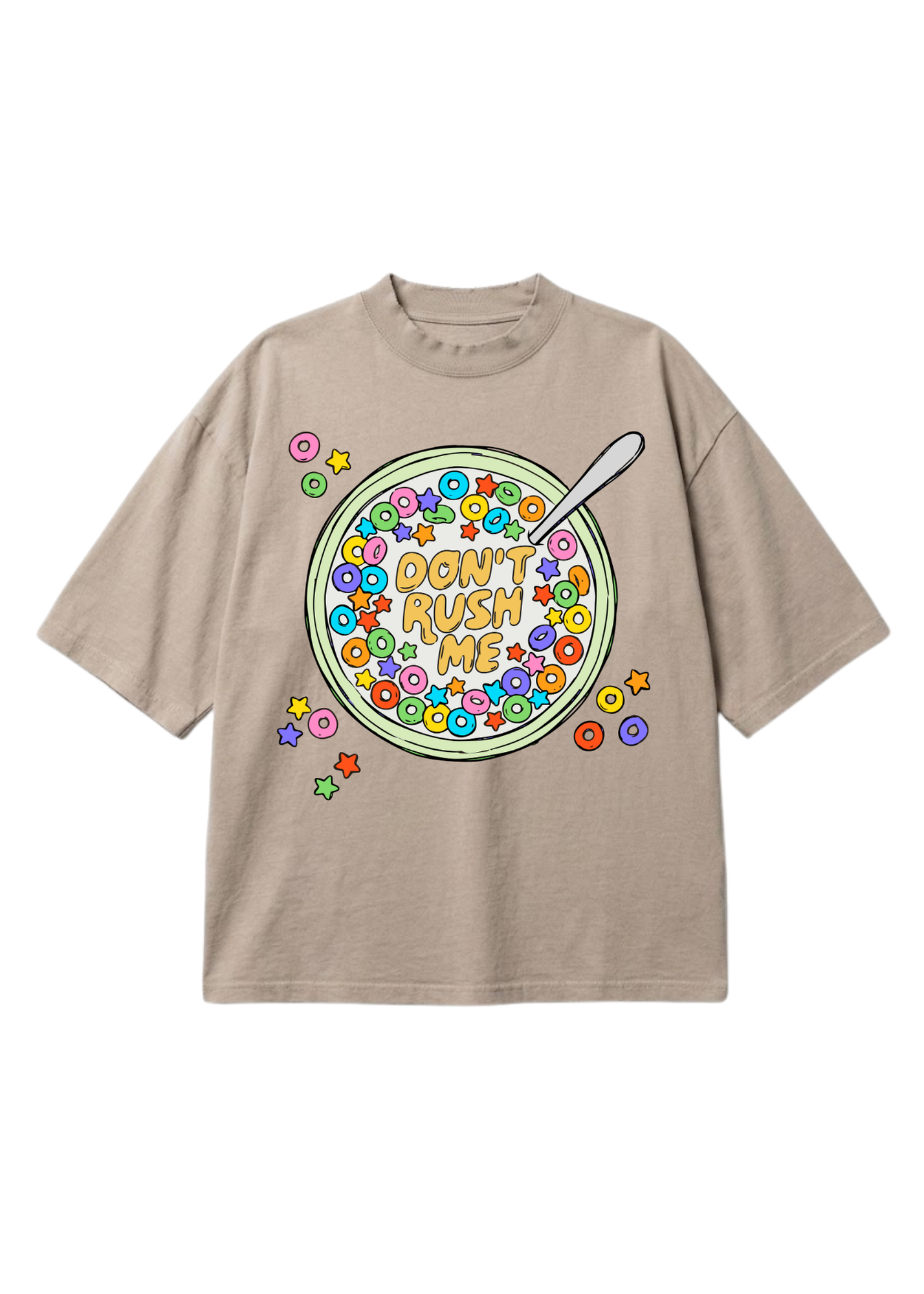 A beige short-sleeve t-shirt with a colorful graphic of a bowl of cereal on the front, featuring the text 'DON'T RUSH ME' and a spoon, set against a plain white background