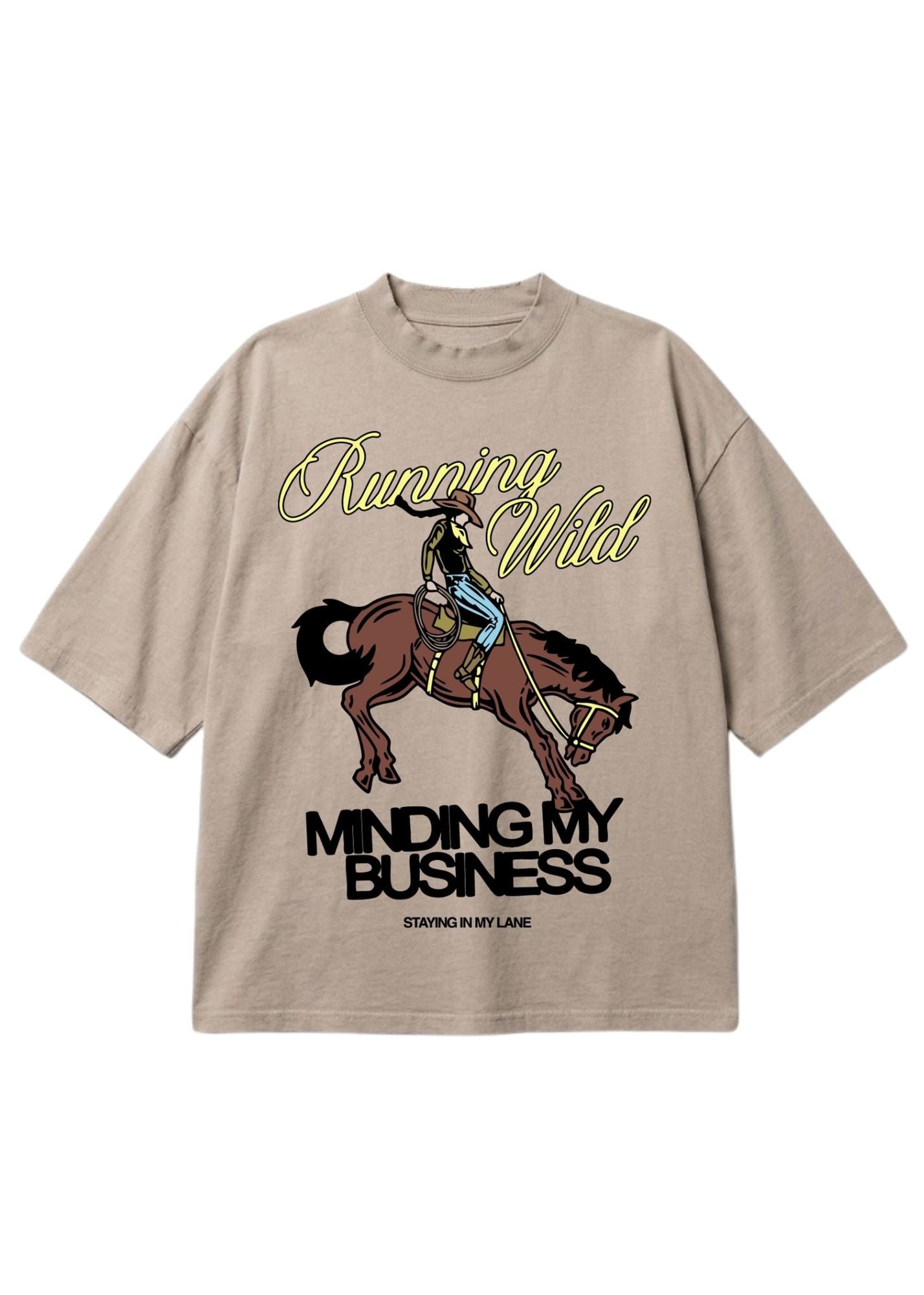 A beige graphic t-shirt featuring a cowboy riding a bucking horse, with the text 'Running Wild' in yellow script and 'MINDING MY BUSINESS' in black block letters. The brand 'STAYING IN MY LANE' is printed at the bottom of the graphic