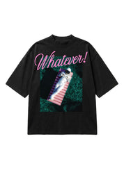 A black short-sleeve graphic t-shirt featuring a pink script 'Whatever!' text and a central print of an astronaut floating on a pink lounge chair in green water.