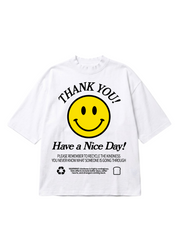 A white short-sleeve t-shirt featuring a yellow smiley face graphic with the text 'THANK YOU! Have a Nice Day!' and recycling instructions printed below, flat lay frontal view