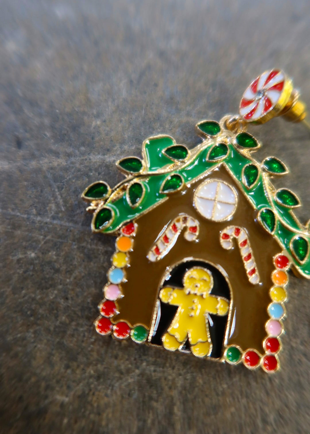 Close up of a gingerbread earring on a dark surface