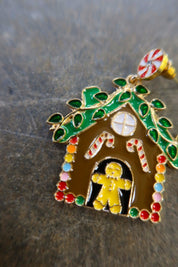 Close up of a gingerbread earring on a dark surface
