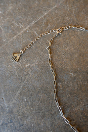 Close up a silver chain necklace with a clasp on a dark background