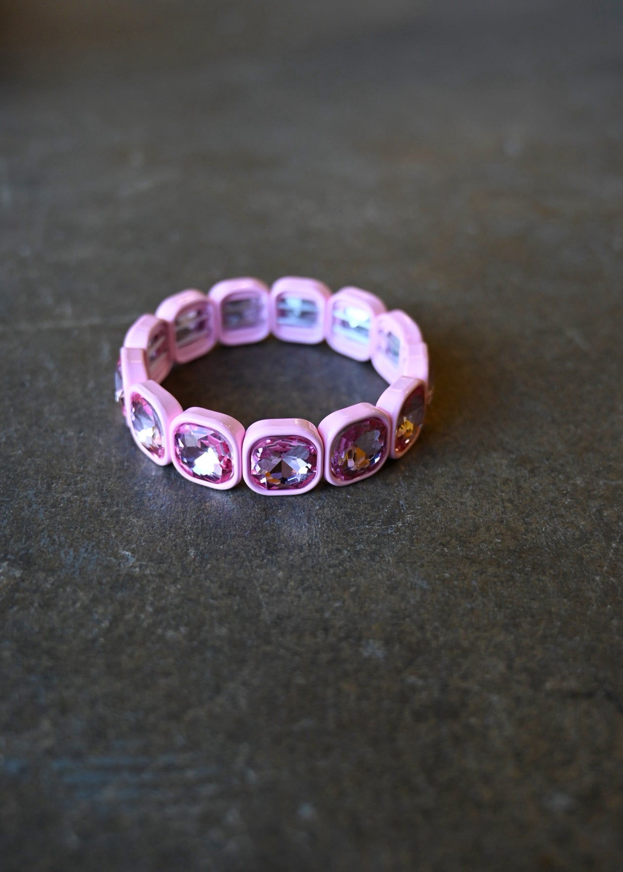 A light pink gemstone bracelet on a dark background