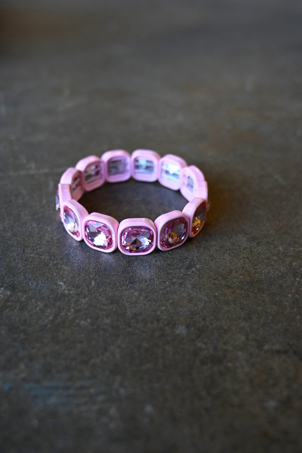 A light pink gemstone bracelet on a dark background