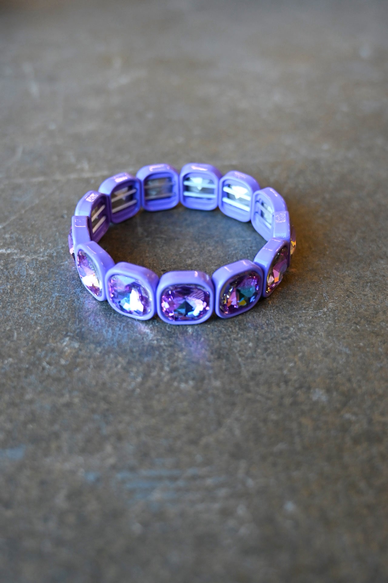 A purple gemstone bracelet on a dark background