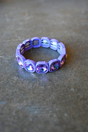 A purple gemstone bracelet on a dark background